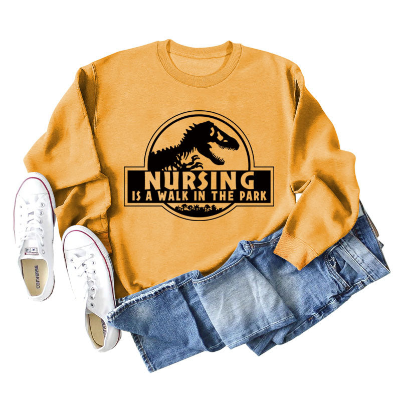 Nursing Is A Walk In The Park Langarm-Sweatshirt mit Rundhalsausschnitt, Dinosaurier-Print