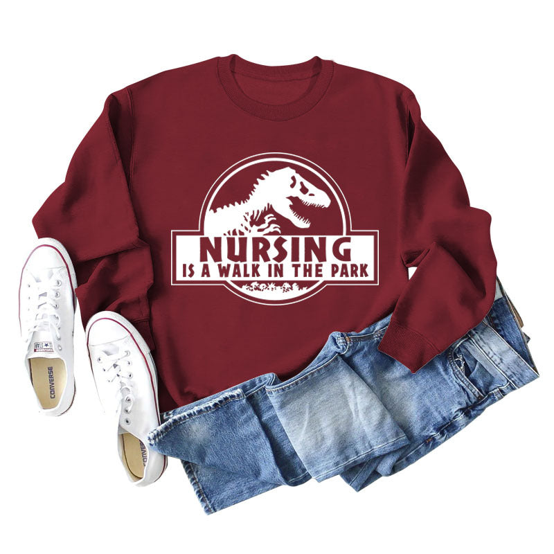 Nursing Is A Walk In The Park Langarm-Sweatshirt mit Rundhalsausschnitt, Dinosaurier-Print
