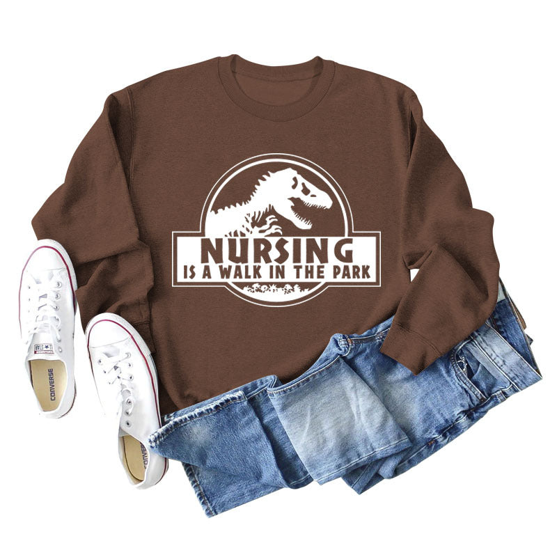 Nursing Is A Walk In The Park Langarm-Sweatshirt mit Rundhalsausschnitt, Dinosaurier-Print