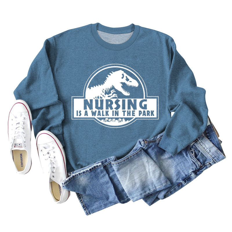 Nursing Is A Walk In The Park Langarm-Sweatshirt mit Rundhalsausschnitt, Dinosaurier-Print