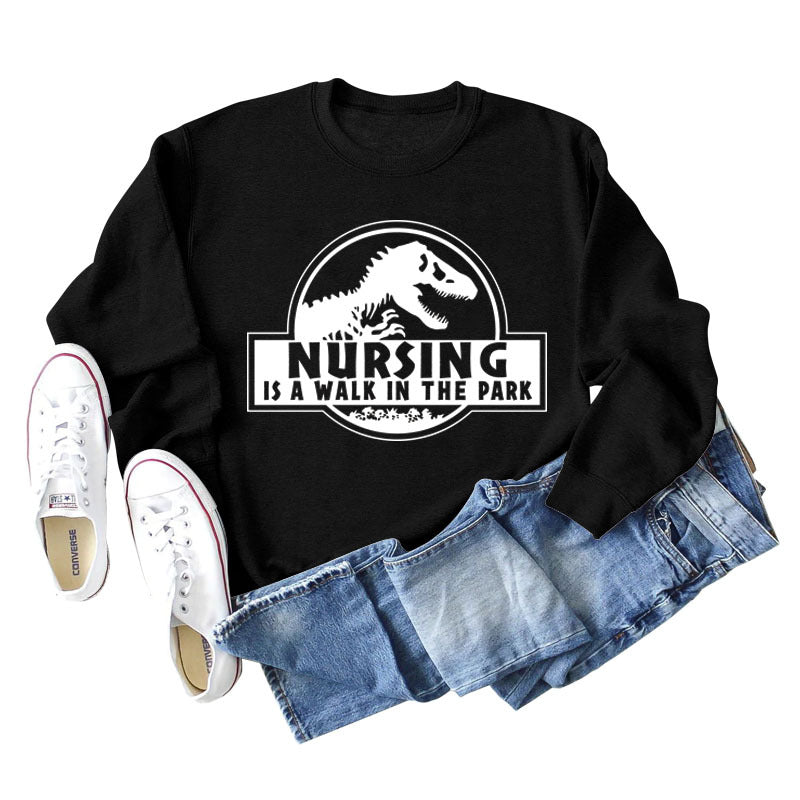 Nursing Is A Walk In The Park Langarm-Sweatshirt mit Rundhalsausschnitt, Dinosaurier-Print